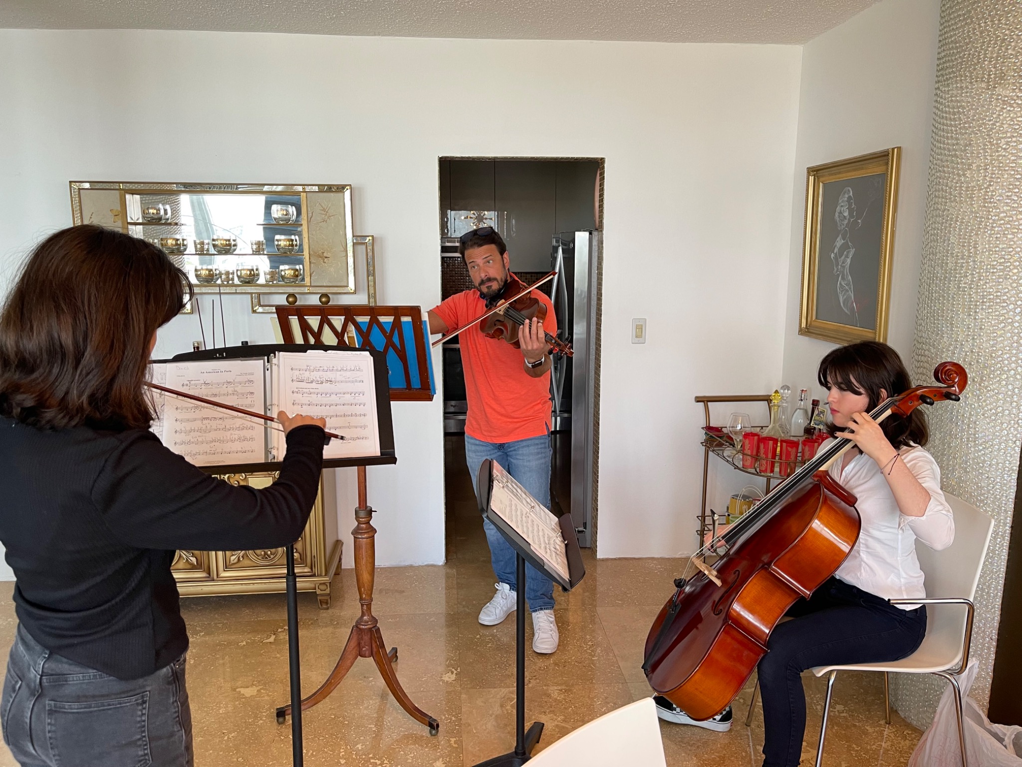 Mr. Djuric demonstrating violin technique while coaching two young string musicians